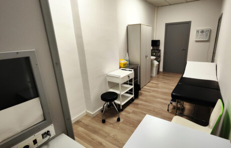 Box 5 Fotografia d'un box més petit, on hi ha un tamboret de color negre, una llitera de color negre, una taula blanca, un armari gris...